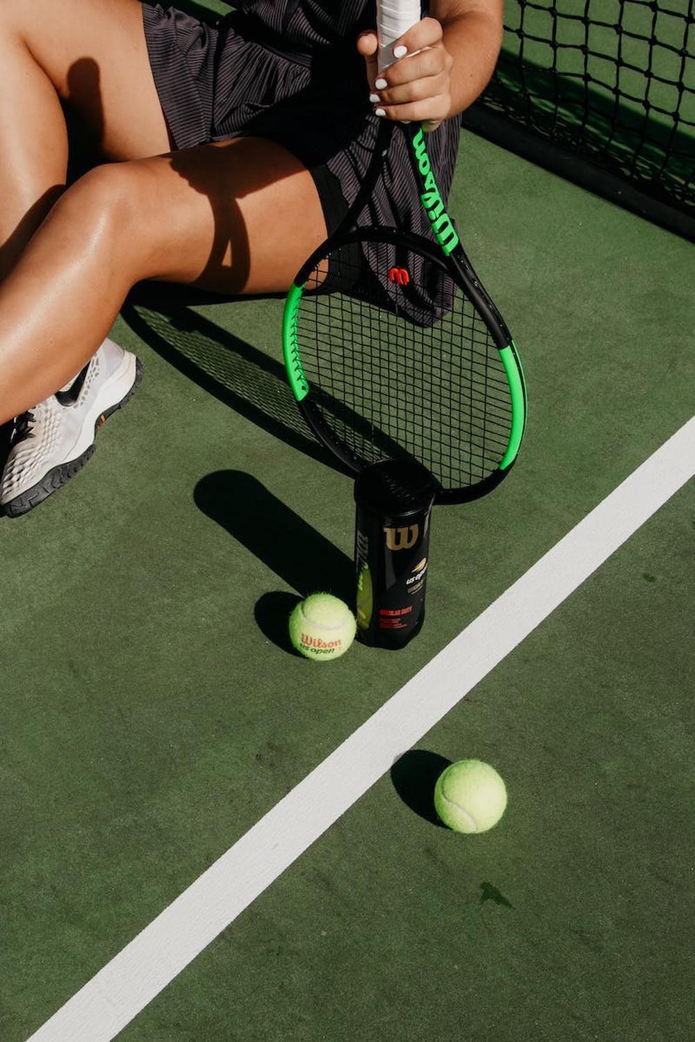green_tennis_balls_and_black_racket